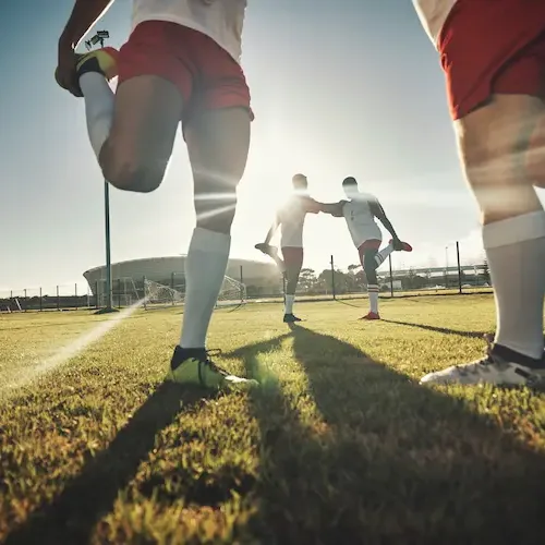 athletes-stretching-before-workout-on-field-in-sun-2026-03-25-05-54-48-utc