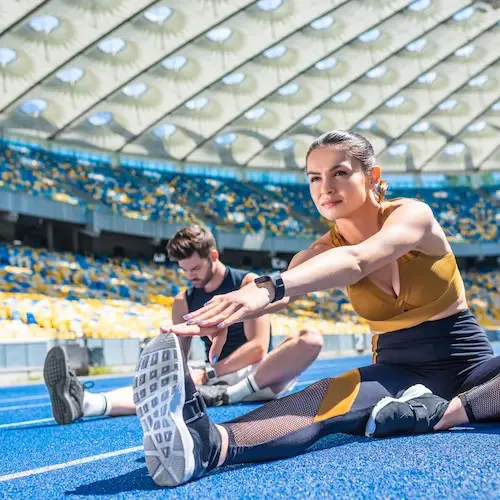 athletic-man-and-woman-stretching-in-stadium-2026-01-06-00-27-08-utc